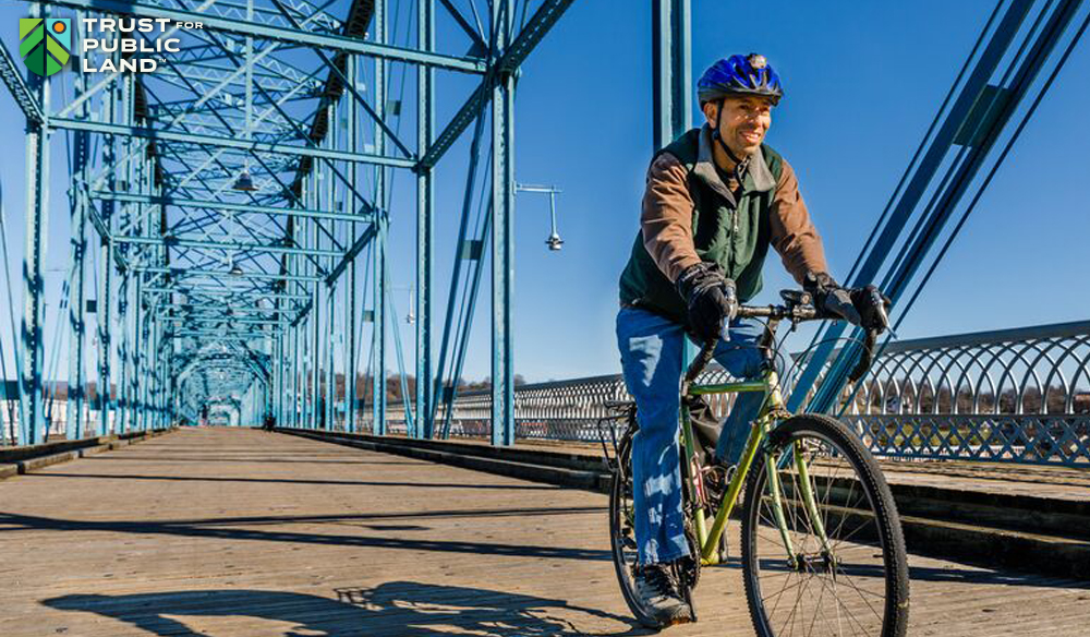 Man riding bike on pedestrian bridge